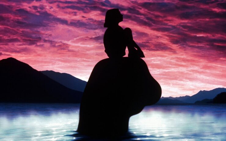 Detail from the poster for Magic in the Water (1995) depicting a girl and the head of a lake monster in silhouette