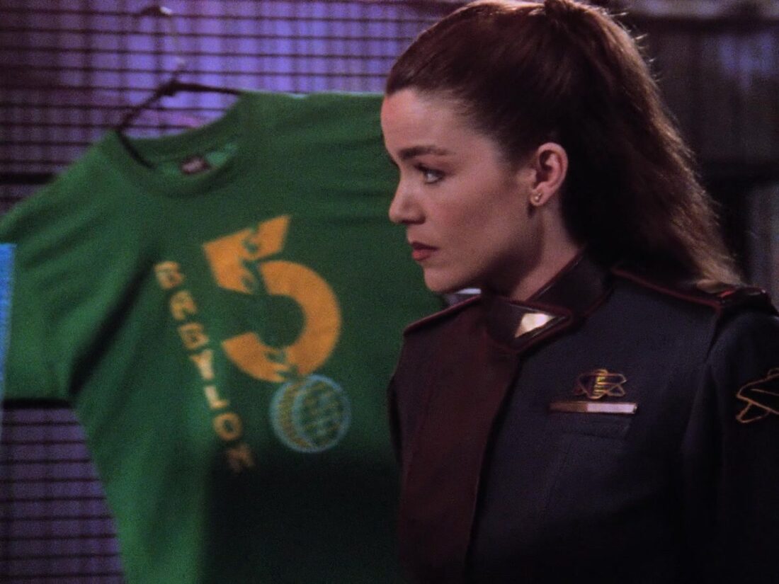 Ivanova stands in front of a t-shirt display in the station giftshop Babylon 5 "There All the Honor Lies"