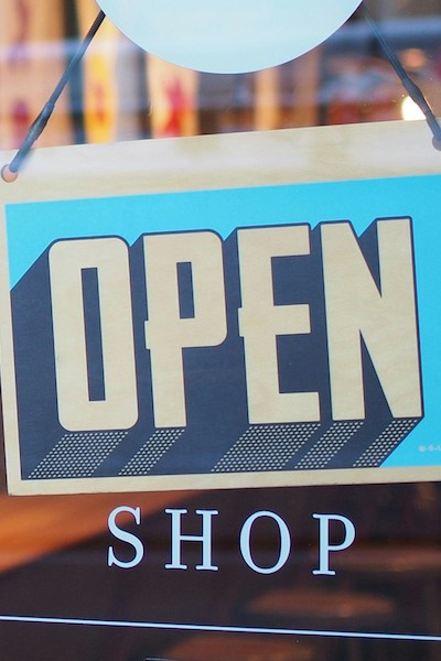 Photo of an "open" sign in a shop's storefront window