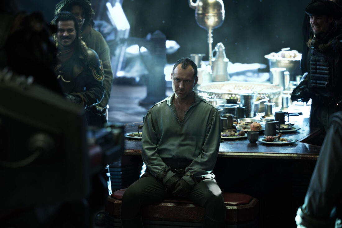 (Center) Jod (Jude Law) about to address a room of pirates in Star Wars: Skeleton Crew's "Zero Friends Again"