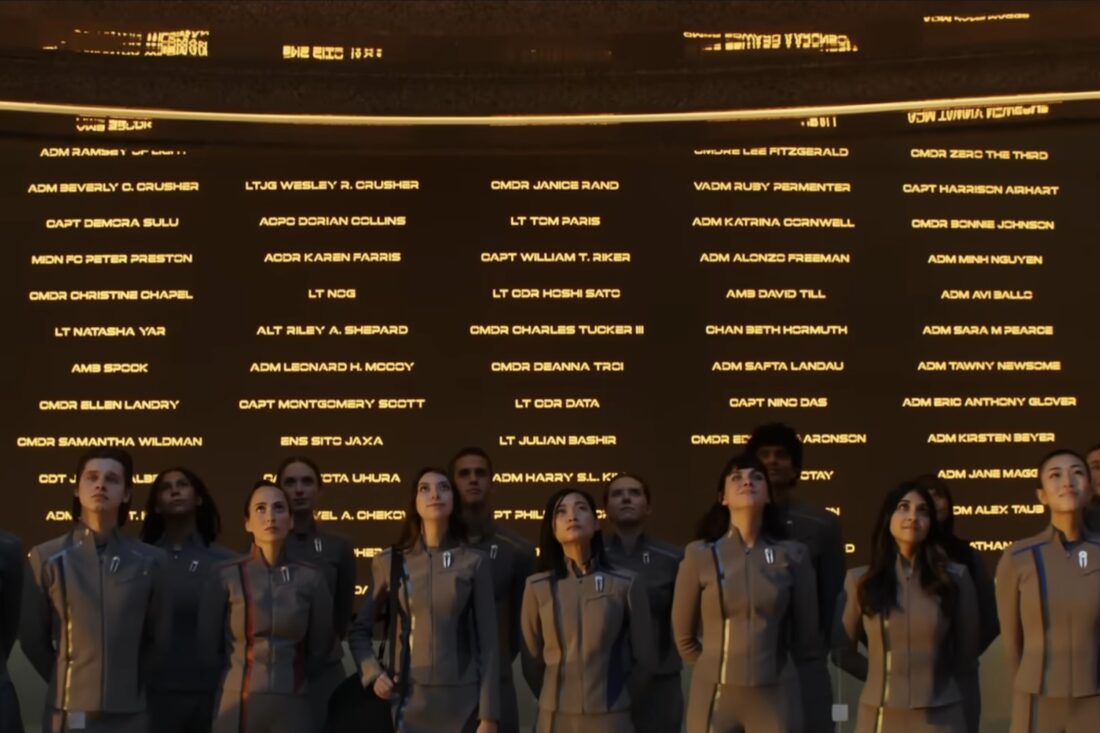 A row of cadets stands before Starfleet Academy's wall honoring Starfleet's best