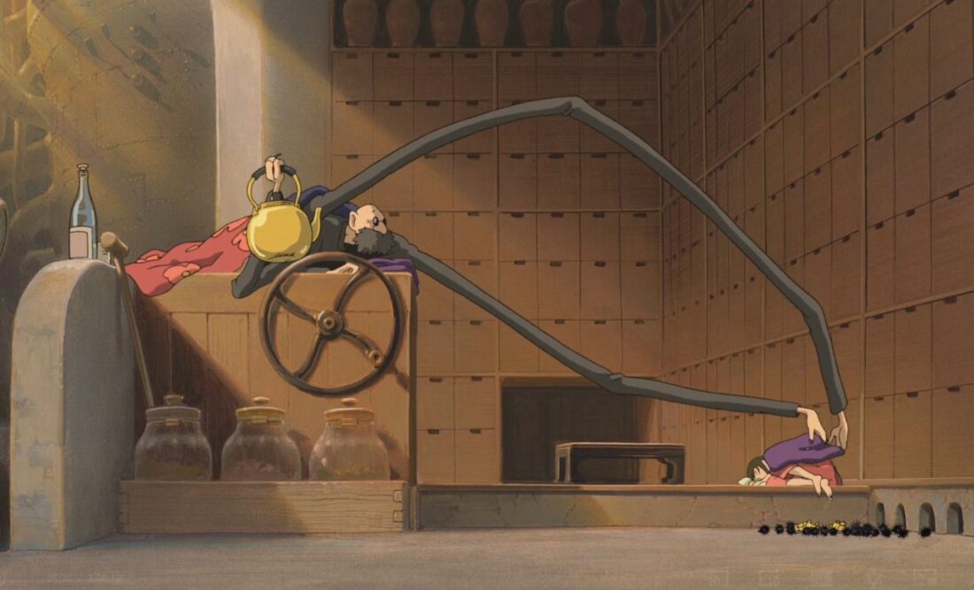Kamaji covers Chihiro with a blanket in a scene from Studio Ghibli's Spirited Away