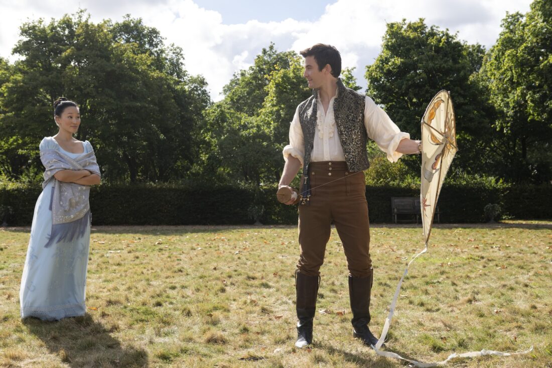 Yerin Ha as Sophie Baek, Luke Thompson as Benedict Bridgerton on a field together with a kite in episode 403 of Bridgerton
