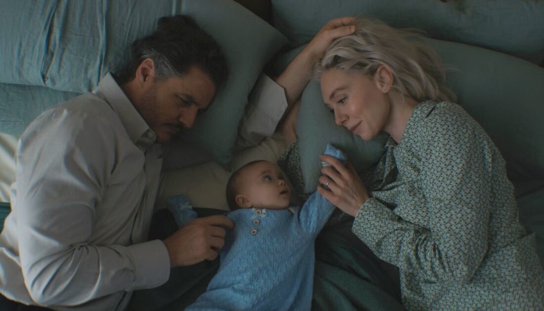 Reed Richards (Pedro Pascal) and Sue Storm (Vanessa Kirby) lay in bed with baby Franklin in The Fantastic Four: First Steps
