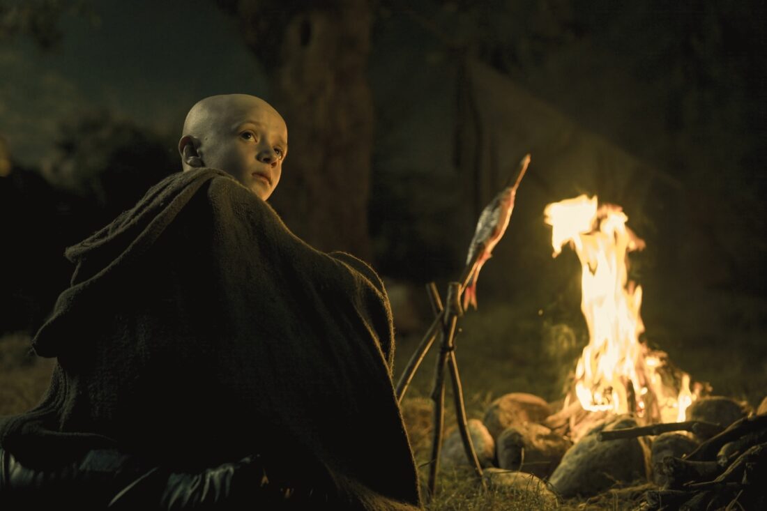 Egg (Dexter Sol Ansell) cooks fish over a campfire in A Knight of the Seven Kingdoms