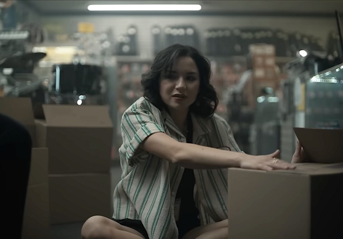 Sarah (Megan Lawless) works a shift in her dad's music shop in Curry Barker's Obsession.