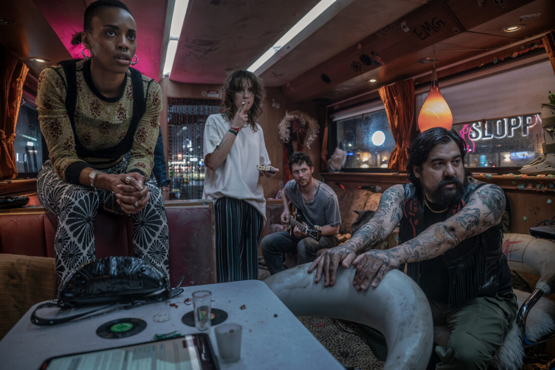 Amaka Umeh as Dee Pharma, Sarah Swire as TC, Noah Reid as Larry, Ryan Kattner as Salamander all watching Lestat paint a cop's face with cocaine - Anne Rice's The Vampire Lestat _ Episode 04